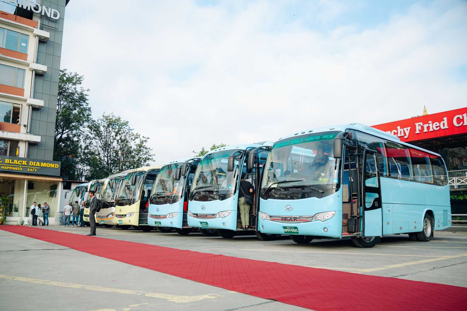 Higer coaches in a long line beside the red carpet